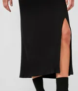 Falda midi negra de rib, con abertura lateral.