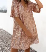 Túnica de corte recto y manga corta con escote en V, completamente recubierta de lentejuelas brillantes.