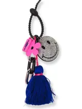 Colgante para celular con correa de silicona negra y dijes colgantes: smiley con strass, flor rosa, borla azul y cadena metálica.