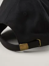 Gorra de béisbol de paño en color azul marino, con etiqueta lateral con logo de la marca.