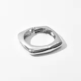 Brazalete rígido plateado con forma cuadrada y cierre de bisagra.