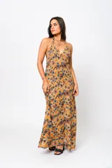 Vestido largo color ocre con estampado floral, escote en V y espalda descubierta.