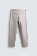 Pantalón chino de corte regular fit, confeccionado en tejido de algodón con elasticidad. Presenta bolsillos frontales, bolsillos traseros de vivo y cierre frontal con cremallera y botón.