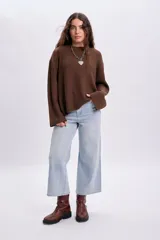 Buzo de punto color marrón con cuello redondo, mangas largas y diseño holgado.