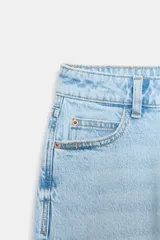 Jeans de tiro alto con corte mom fit, cinco bolsillos y cierre frontal con cremallera y botón.