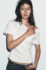 Camiseta blanca de algodón compacto, corte slim fit, con cuello barco y manga corta.