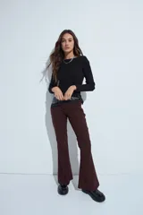 Pantalón de corte oxford con ajuste en la cadera y pierna acampanada, confeccionado en tejido fluido de color marrón oscuro.