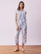 Conjunto de pijama marca René Rofé, compuesto por remera de mangas cortas con escote en V abotonado y pantalón capri con cintura elastizada. Diseño estampado con flores azules sobre fondo blanco.