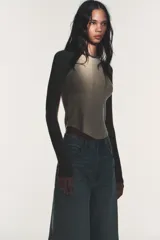Camiseta de manga larga tipo ranglán con cuello redondo. Presenta un diseño bicolor con cuerpo en tono beige y mangas en gris jaspeado, con bajo redondeado.