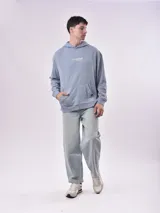 Buzo canguro celeste con capucha y cordón ajustable. Estampado frontal con la frase "Let's start rolling. Forget the rules". Corte holgado con puños y cintura acanalados.