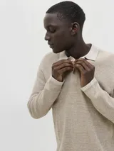 Polo de manga larga con fit relajado, confeccionado en tejido de punto con textura estructurada. Presenta cuello clásico con cierre de botones y hombros caídos.