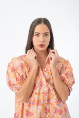 Vestido corto verde con estampado floral, cuello alto, mangas cortas abullonadas y corte holgado.