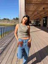 Musculosa gris oscuro de corte recto, con cuello redondo y diseño sin mangas. Presenta un pequeño bordado frontal de sol en tono amarillo y detalle de ribetes.