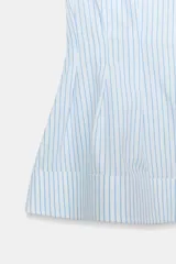 Camisa de algodón sin mangas con cuello solapa, diseño a rayas celestes y blancas, pliegues en la cintura y bajo evasé. Cierre frontal con botones ocultos.