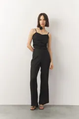 Top negro sin mangas de tela satinada y texturizada, con costuras que generan frunces.