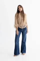 Pantalón de jean azul gastado con proceso de gastado localizado, corte con cintura media entallada y piernas de corte recto (Boot Cut) levemente oxford desde la rodilla.