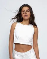 Top corto tipo halter de cuello a la base, confeccionado en gabardina de algodón. Presenta pinzas delanteras que aportan volumen, cierre lateral y detalle de abertura con botón en la espalda. Se caracteriza por sus costuras a contratono.