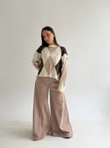 Sweater de punto con diseño de rombos en tonos marrón, beige y celeste, de corte holgado, cuello redondo y manga larga.