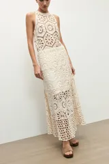 Falda midi beige de tejido crochet con diseño de motivos geométricos perforados.