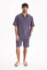 Bermuda negra de muselina con corte baggy, estilo deportivo y cordón ajustable en la cintura.