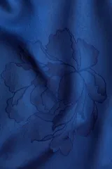 Blusa de tejido jacquard con acabado satinado y diseño floral en relieve. Presenta cuello elevado, mangas largas abullonadas con puños abotonados y cierre posterior con botones forrados.