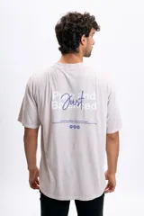 Remera oversize color gris claro con estampado trasero en color azul que dice "Pure and Just Balanced" y una frase motivacional debajo.