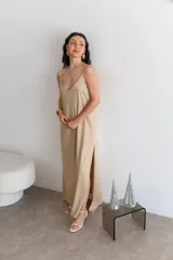 Vestido largo rojo brillante, con escote en V y tirantes finos. Presenta un corte holgado y abertura lateral en la falda.