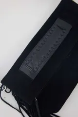 Cartera bandolera de gamuza azul marino con flecos en los laterales y solapa frontal decorada con detalle de cuero liso. Cuenta con asa ajustable y herrajes metálicos plateados.