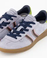 Championes Coolway modelo Kiro Lavender Rush, confeccionados en gamuza de color lila con detalles en marrón, rosa, verde lima y suela de goma marrón translúcida. Presentan diseño retro con doble franja lateral ondulada y cordones oscuros.