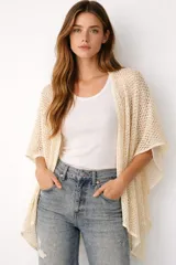 Poncho de tejido calado color beige, con mangas cortas y corte asimétrico.