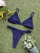 Conjunto de bikini azul con corpiño triangular fijo y bombacha colaless regulable.