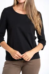 Remera de algodón con elastano, color negro, con mangas 3/4 y cuello redondo. Presenta un calce al cuerpo y está confeccionada en algodón peinado suave y resistente.