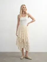 Falda midi asimétrica de encaje color crudo, con diseño de capas superpuestas y cintura elastizada.
