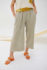 Pantalón capri color beige, de tejido acanalado, con cintura elástica y bolsillos laterales.