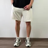 Short de algodón color beige melange, de diseño cómodo y holgado con bolsillos laterales y terminación descosida en las perneras.