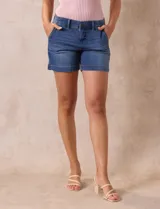 Short blanco de algodón elastizado, con pretina con pasadores, botón y cierre. Delantera con bolsillos inclinados y trasera con bolsillos simulados.