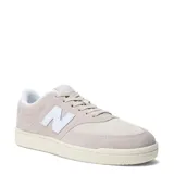 Championes urbanos New Balance modelo Court, color beige con detalles en blanco. Confeccionados en una combinación de gamuza y malla, presentan el logo 'N' característico en los laterales y una suela de goma de estilo retro.