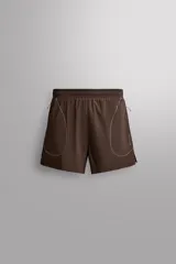 Short de running color marrón, confeccionado en tejido técnico elástico con forro interior. Cuenta con cintura elástica ajustable, bolsillos laterales con cierre de cremallera oculto y aberturas en las perneras.