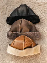 Gorro de cuero con interior de piel sintética y costuras visibles en relieve.