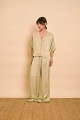 Blusa de satén color verde menta, con escote en V, mangas cortas y cierre frontal con botones.