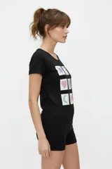 Remera de algodón blanca de manga corta, con cuello redondo y estampado frontal con la leyenda "New York" y flores abstractas en tonos marrones y rosados.