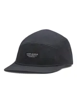 Gorra tipo camper de cinco paneles color negro, confeccionada en lona resistente. Presenta una etiqueta rectangular con el logo de la marca en el frente y visera plana.