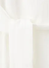 Vestido corto blanco sin mangas, con cuello redondo y detalle de lazo lateral en la cintura.