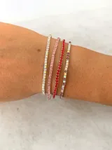 Set de pulseras elásticas compuestas por hileras de strass en tonos rojo, plateado y rosado.