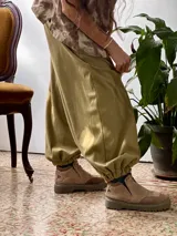 Conjunto compuesto por una remera de cuello redondo y un pantalón tipo balloon de tiro alto con puños elásticos en los tobillos y bolsillos laterales. Ambas prendas están confeccionadas en rib de algodón color verde oliva.