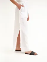 Pollera larga blanca de lino, con tajos laterales y diseño de tiro alto.
