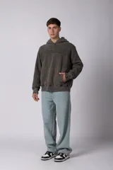 Buzo canguro oversize con efecto lavado desgastado, confeccionado en friza pesada. Presenta diseño con recortes, capucha amplia y puños y ruedo acanalados.