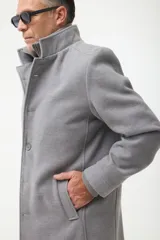 Gabán azul marino con cuello alto y pechera desmontable con cierre.