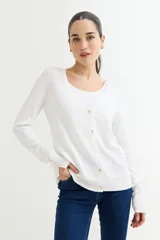 Cardigan blanco de tejido de punto fino, con escote en V, cierre frontal con botones dorados y mangas largas con puños ajustados con botones dorados.