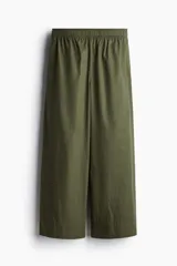Pantalón de corte holgado en algodón, con piernas amplias de largo tobillero. Presenta tiro alto, cintura elástica y bolsillos laterales discretos.